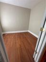 Unfurnished room featuring dark wood-style flooring and baseboards