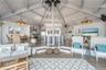 Living room with a notable chandelier, high vaulted ceiling, a healthy amount of sunlight, and wood finished floors