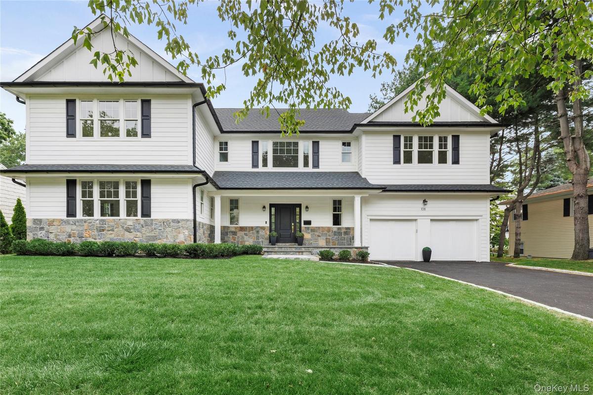 Stunning colonial with white composite siding, stone veneer and a 2 car attached garage