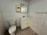 Bathroom with tile patterned flooring, vanity, toilet, and tile walls