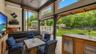 Outdoor entertainment area featuring a corrugated metal roof, wood shake bar with a stone countertop, built-in media console with television, exterior