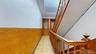 Corridor featuring light floors and wainscoting