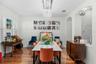 Formal dining room with stylish chandelier and bright natural light.