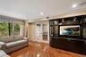 Wood-finish flooring throughout, featuring a large built-in media cabinet with display shelving and accent lighting
