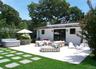Rear view of house with an outdoor living space, a hot tub, outdoor dining space, a patio, and view of scattered trees