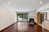 Spacious living area featuring rich wood-finish flooring, a contemporary fireplace with a classic mantel, and recessed lighting