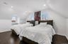 Bedroom with vaulted ceiling, dark wood-style flooring, and recessed lighting