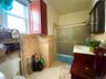 Bathroom featuring shower / bath combination with glass door, tile walls, vanity, and light tile patterned floors
