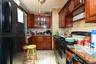 Kitchen with black appliances, backsplash, dark stone countertops, light tile patterned flooring, and glass insert cabinets