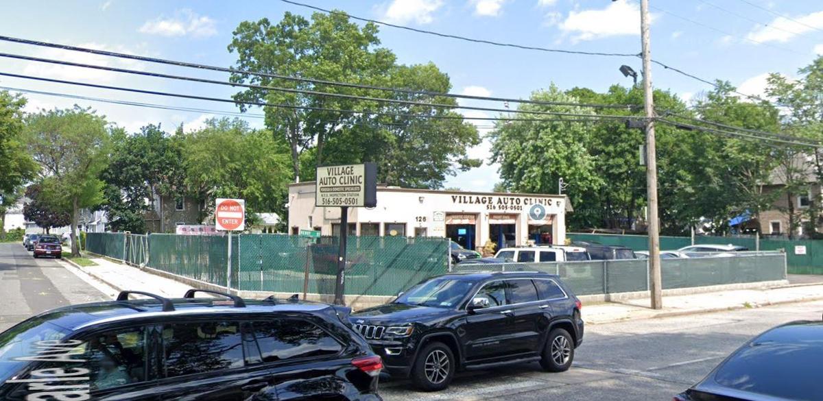 View of asphalt street featuring sidewalks, curbs, and traffic signs