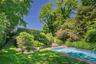 Rectangular in-ground swimming pool with stone coping and surrounding lawn