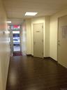 Hallway with a drop ceiling and wood finished floors