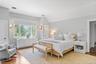 Bedroom with vaulted ceiling, light wood finished floors, and visible vents