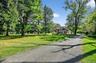 View of community featuring a lawn and view of scattered trees