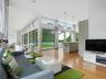 Living area with a high ceiling, light wood-type flooring, and recessed lighting