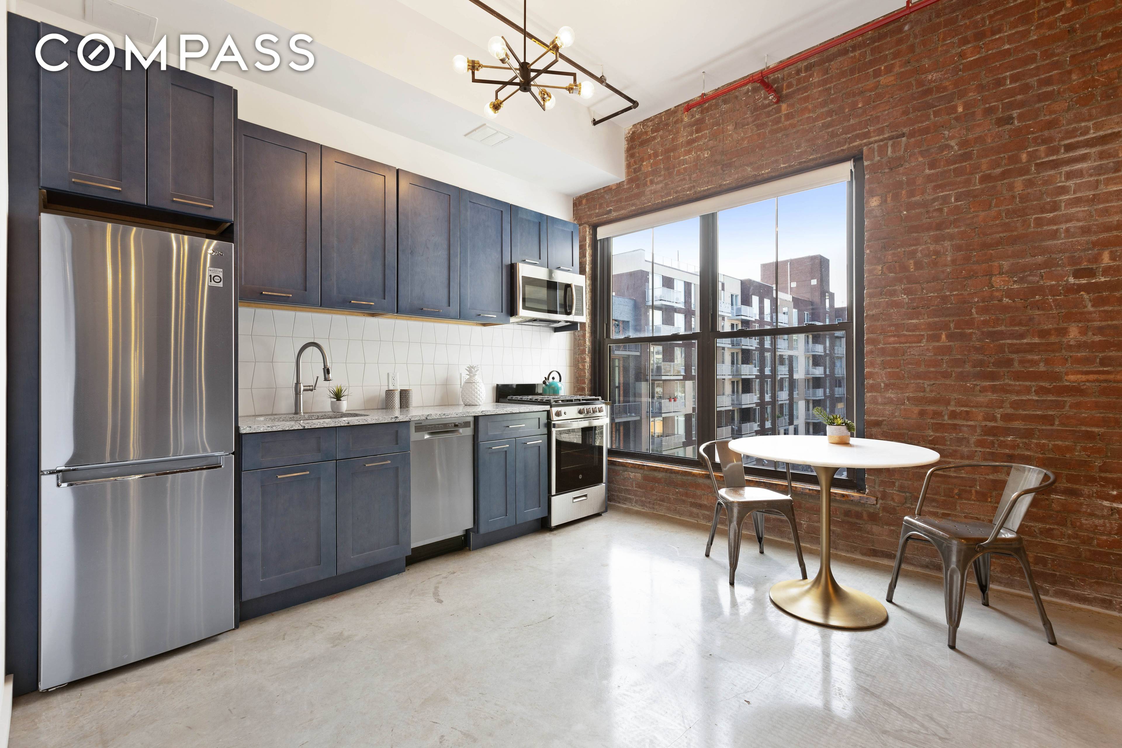 Authentic Loft with exposed brick, high ceilings, concrete floors, and walls of windows.