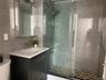 Full bathroom with tile walls, vanity, a stall shower, and tasteful backsplash