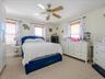 Master Bedroom featuring light-colored wall paint, two windows with wood blinds and curtain rods, and a ceiling fan with light fixture