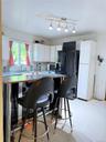 Kitchen featuring wood counters, white cabinets, black refrigerator with ice dispenser, and a breakfast bar