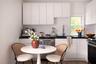 Kitchen featuring appliances with stainless steel finishes, white cabinets, dark countertops, and wood finished floors