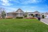 View of front of house with a front yard and a shingled roof