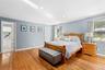 Bedroom featuring multiple windows, light wood finished floors, ornamental molding, and recessed lighting