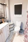 Bathroom featuring light marble finish flooring, vanity, and curtained shower