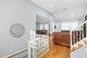 Living room featuring light wood-type flooring, vaulted ceiling, recessed lighting, and stairs