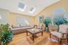 Living area featuring vaulted ceiling, a skylight, and wood finished floors
