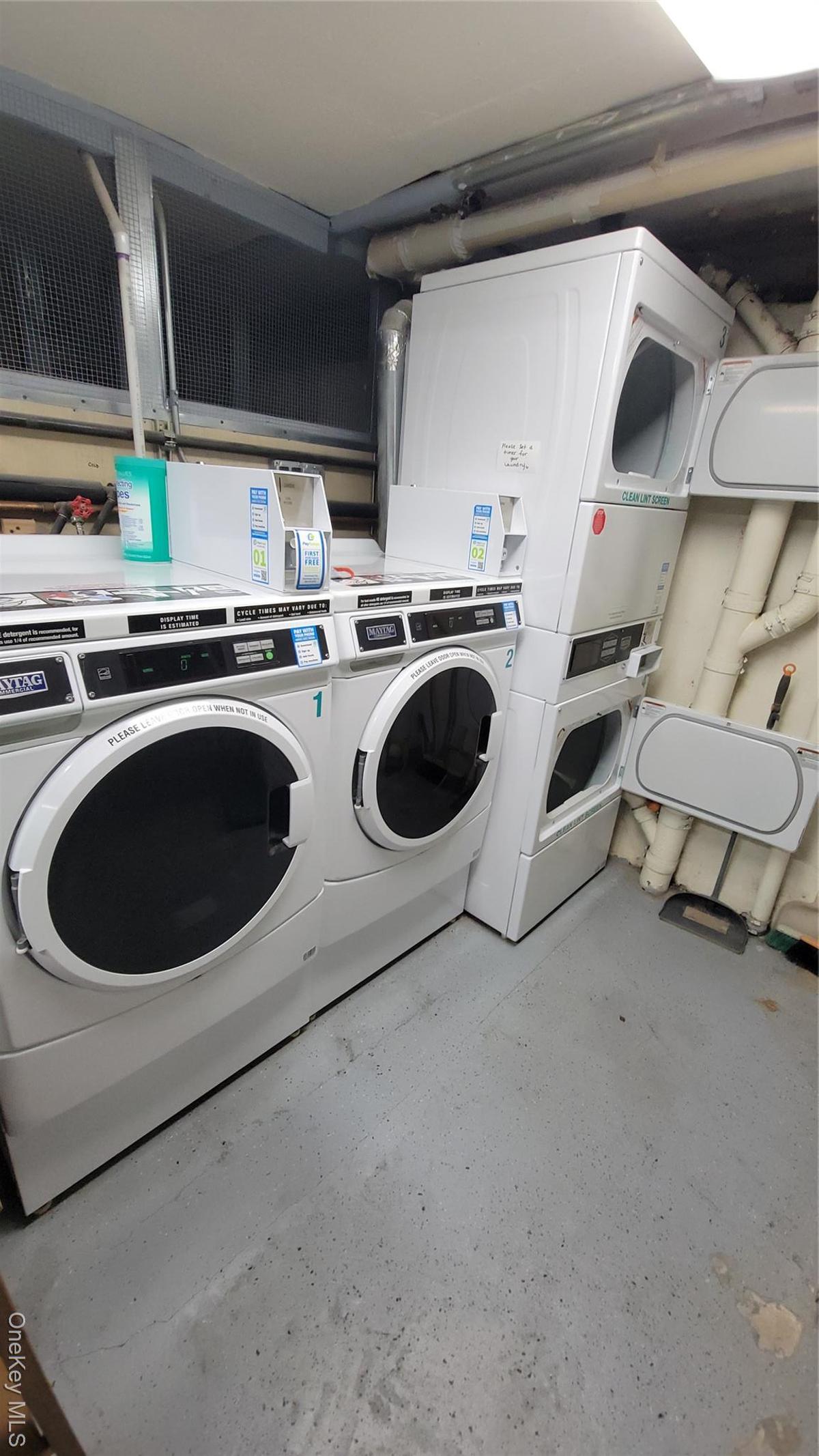 Shared laundry room featuring stacked washing machine and dryer and independent washer and dryer