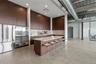 Kitchen featuring freestanding refrigerator, backsplash, a kitchen bar, a large island, and a towering ceiling