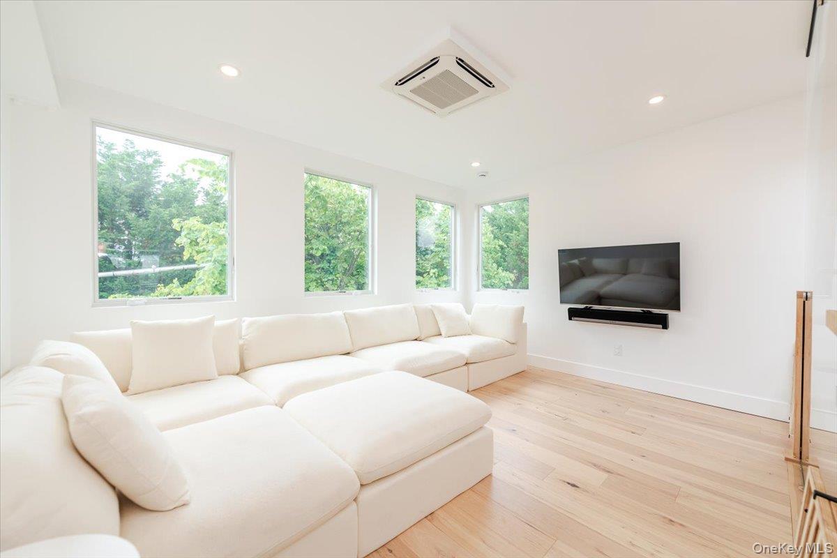 Living room featuring cooling unit, light wood-type flooring, and recessed lighting