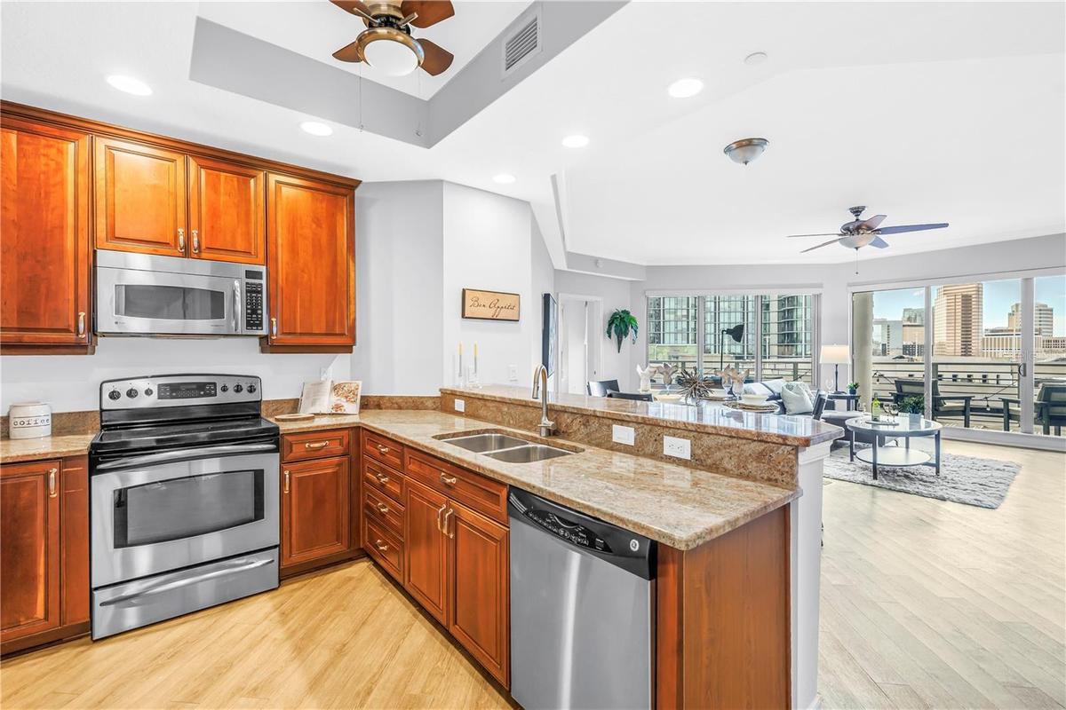 Open Kitchen with Granite High Top Seating and Easy Conversation to the Living, Dining, and Outdoor Space.
