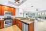 Open Kitchen with Granite High Top Seating and Easy Conversation to the Living, Dining, and Outdoor Space.