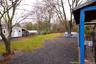 View of grassy yard featuring an outbuilding and a greenhouse