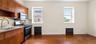 Kitchenette featuring wood-finish cabinetry, stainless steel appliances, and a single basin sink