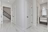Corridor with recessed lighting, light marble finish flooring, and stairway