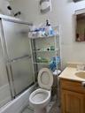 Full bathroom featuring bath / shower combo with glass door, vanity, tile walls, and tile patterned floors