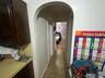 Hallway with arched walkways and baseboards
