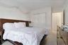 Neutral toned bedroom featuring wall-to-wall carpeting and a large built-in closet with sliding doors