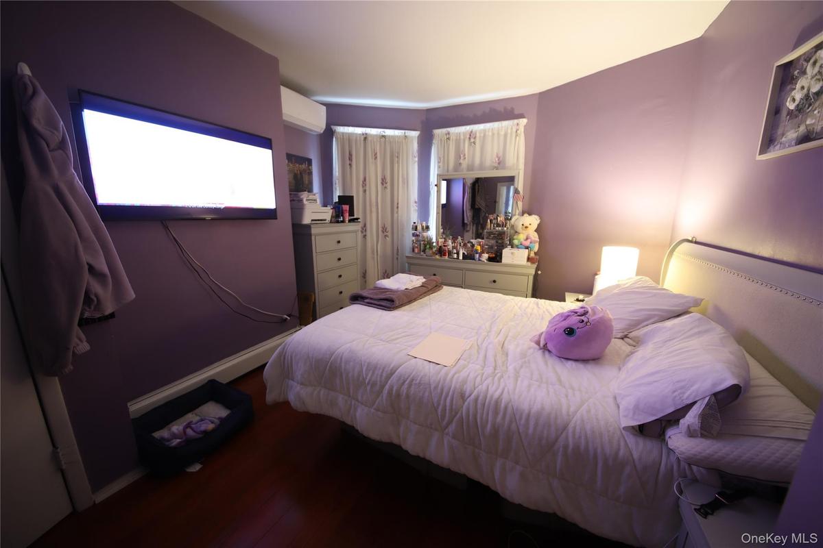 Bedroom featuring a wall mounted air conditioner and wood finished floors