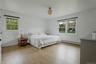 Bedroom featuring multiple windows, a baseboard radiator, and light wood-style floors