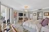 Custom walk in primary closet w/ tons of drawers on both sides of island and glass uppers
