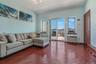 Living area featuring dark wood-style floors and a wall mounted air conditioner