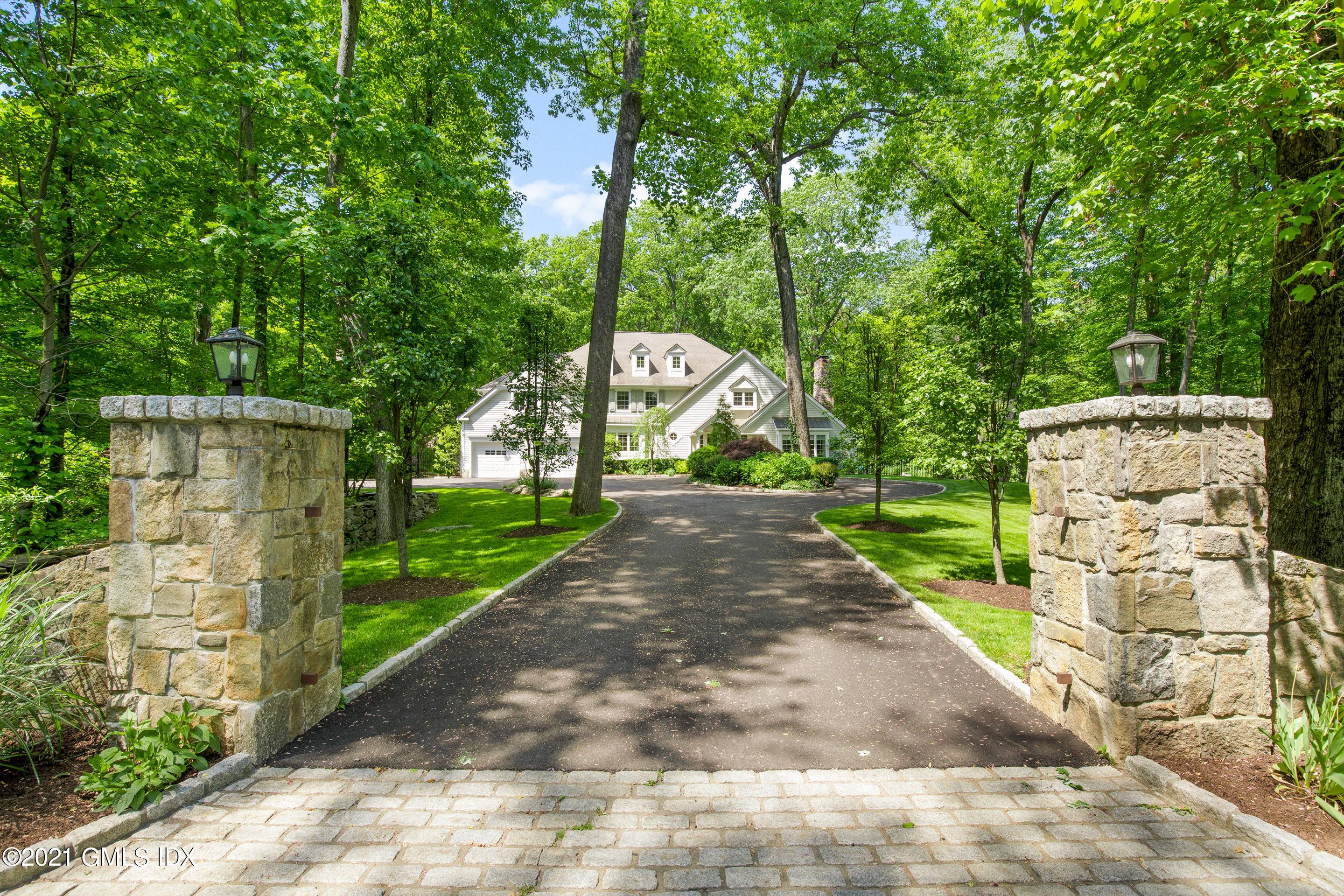At the end of a quiet cul de sac and stately driveway with stone pillars, sits an inviting country home on four verdant acres.