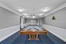 Community game room with a regulation billiards table, lounge seating, and arched architectural details.
