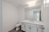 Guest bathroom #4 continues the home’s clean, modern aesthetic with a bright, streamlined design. The vanity features shaker-style cabinetry with brus