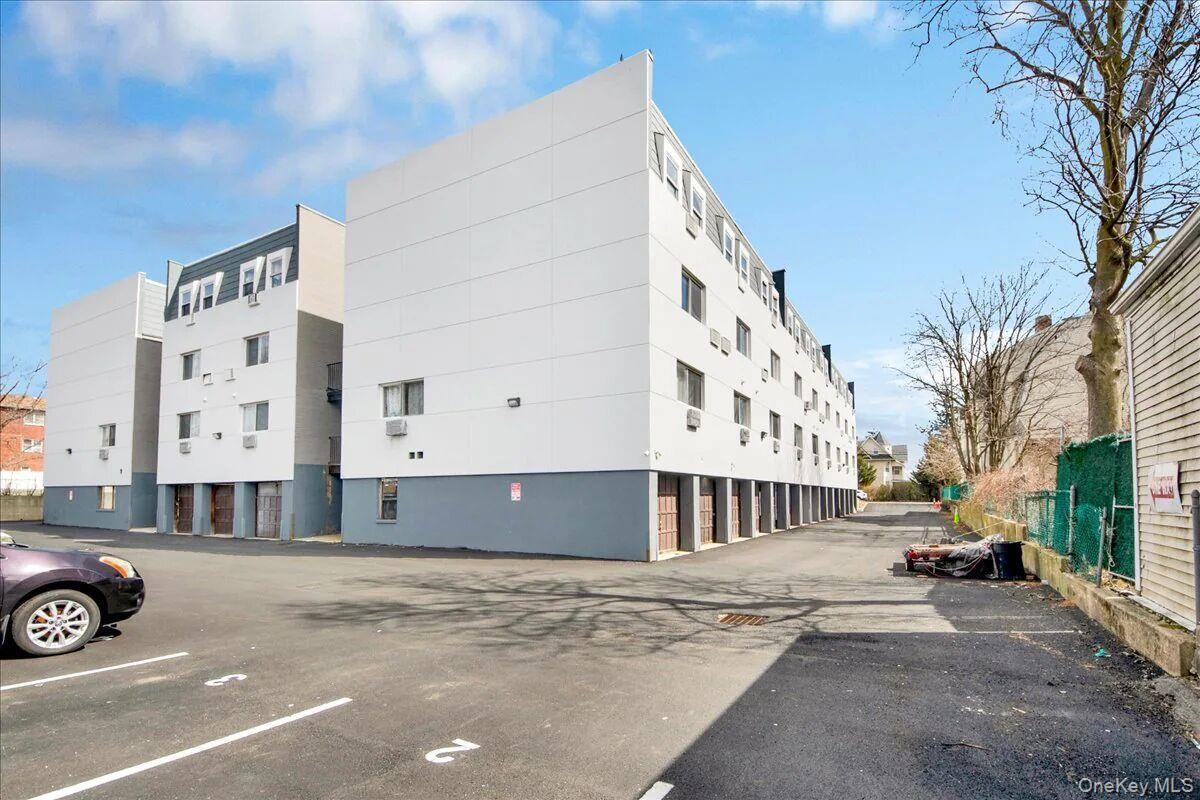 Multi-story building featuring white facade with gray base