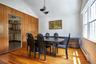 Dining area featuring hardwood flooring, an angled ceiling, wood paneling, and multiple windows
