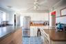 Kitchen featuring high end refrigerator, ornamental molding, white cabinets, and ceiling fan
